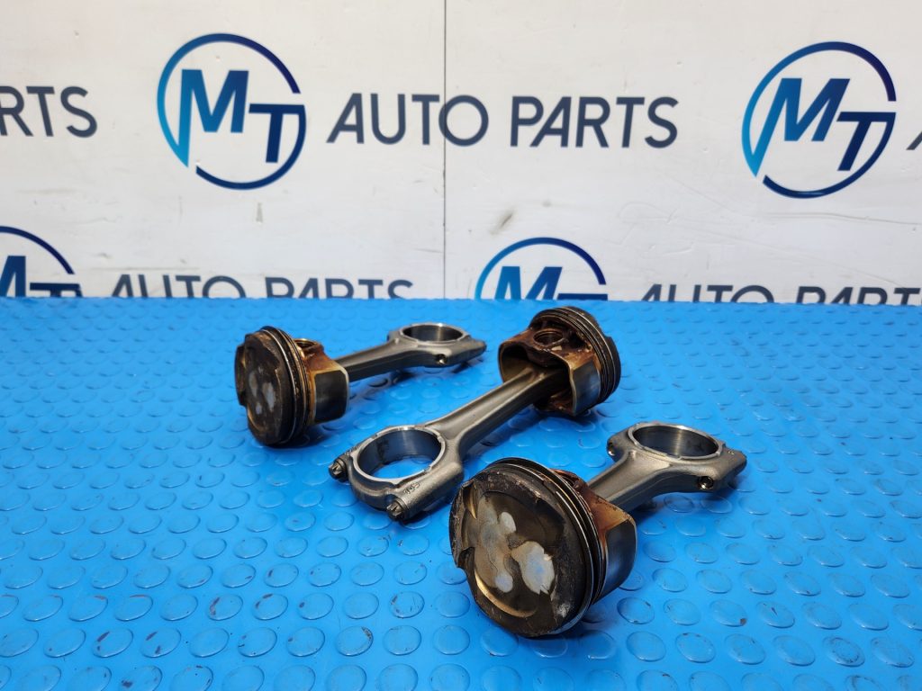 Three BMW 2 Series engine pistons with connecting rods