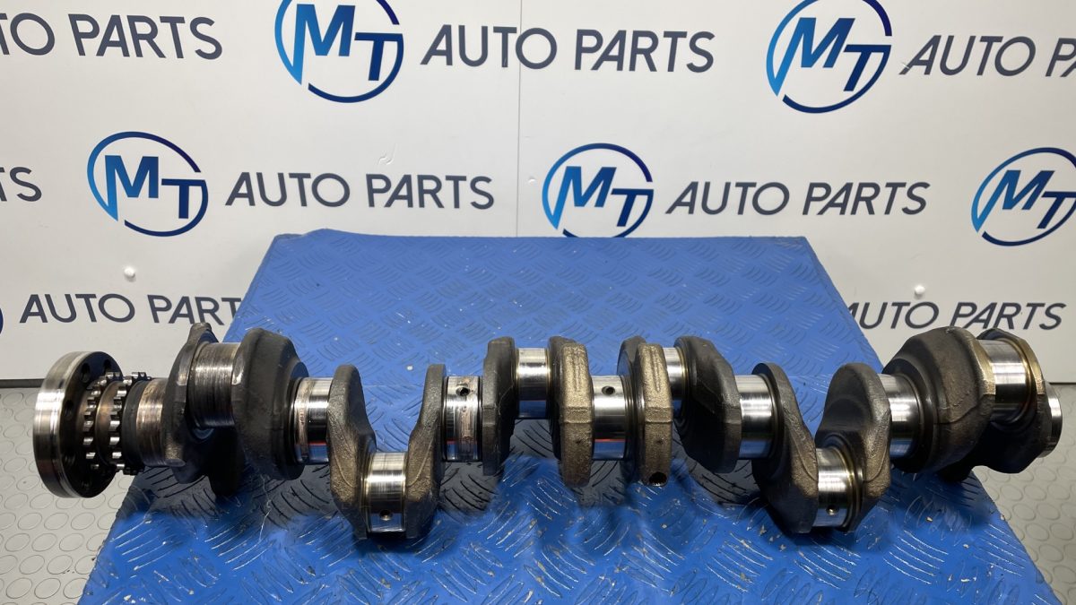 BMW N57D30C engine crankshaft on a blue workshop mat