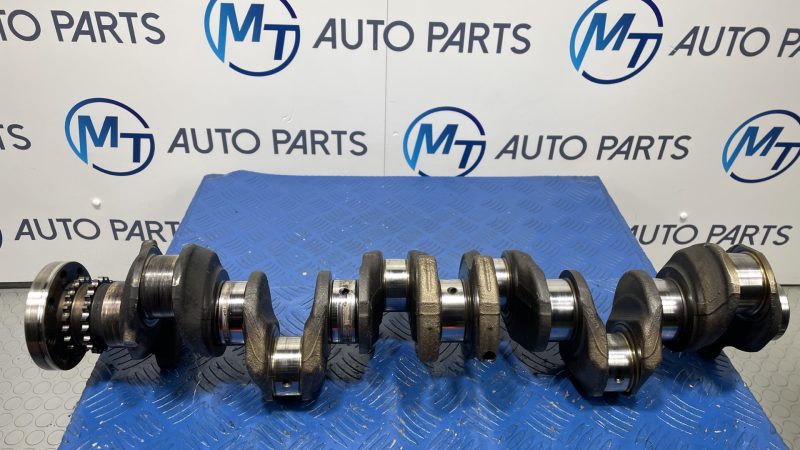 BMW N57D30C engine crankshaft on a blue workshop mat