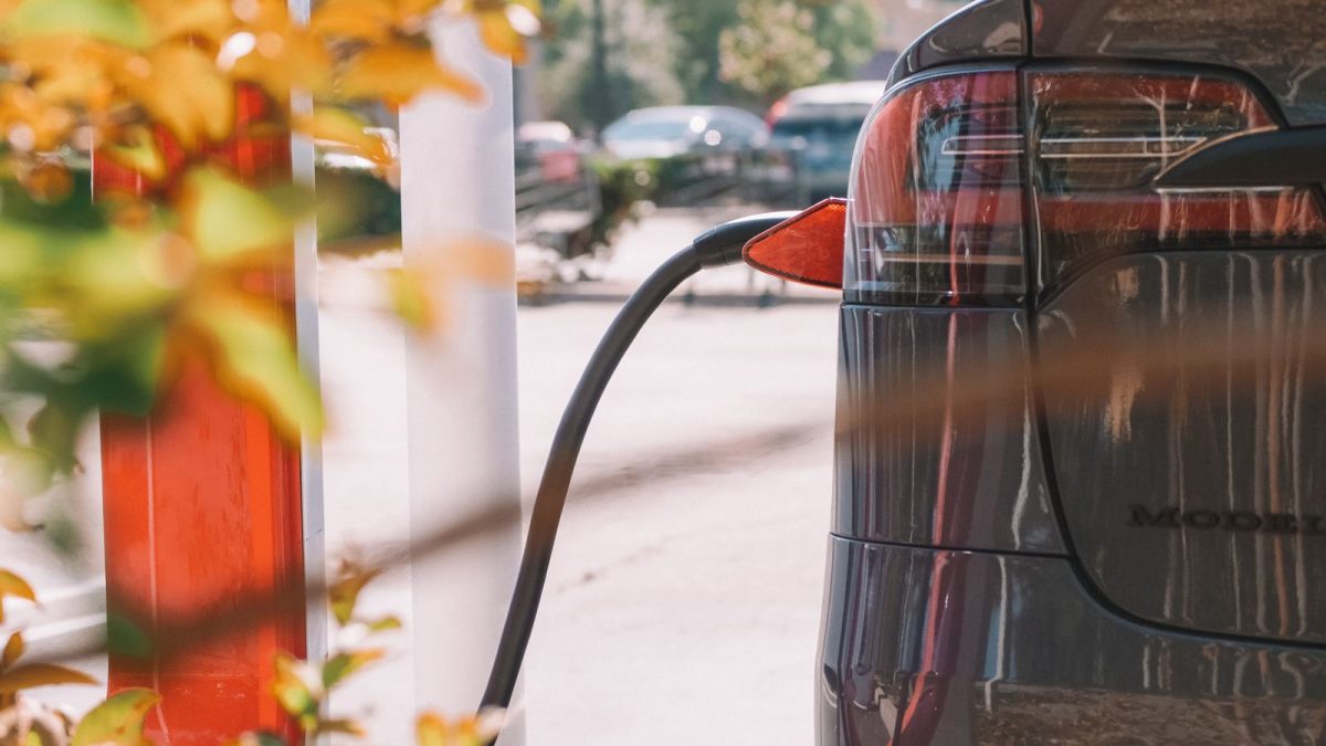 Electric car plugged into a charger on a residential street